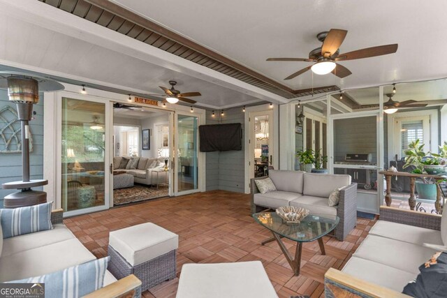 sunroom / solarium featuring outdoor lounge area and a ceiling fan