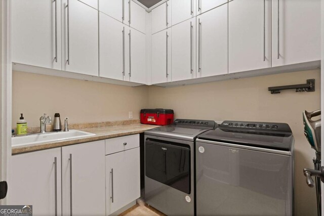 laundry area with a sink, cabinet space, and washer and clothes dryer