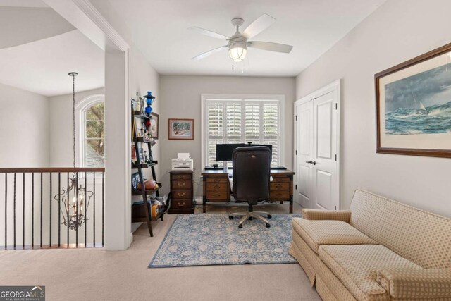 carpeted office space with a ceiling fan