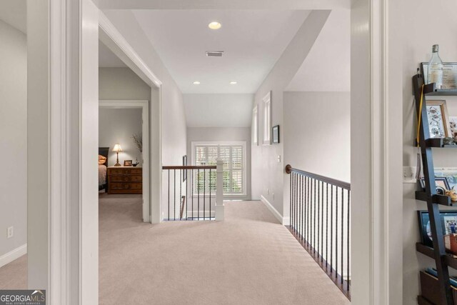 hall featuring an upstairs landing, recessed lighting, visible vents, and carpet floors