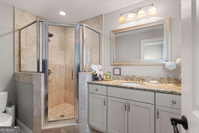 bathroom featuring toilet, recessed lighting, a stall shower, and vanity