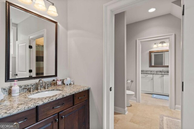 bathroom featuring recessed lighting, vanity, baseboards, and toilet