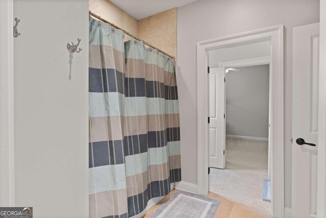 bathroom with tile patterned floors and a shower with shower curtain