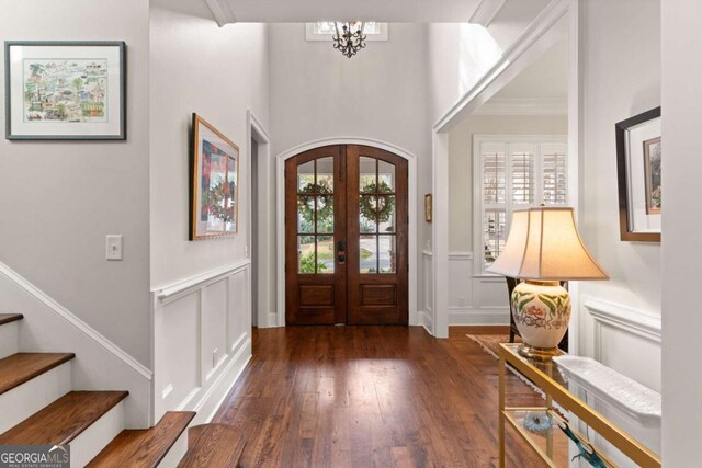 foyer entrance with a decorative wall, plenty of natural light, hardwood / wood-style flooring, and stairs