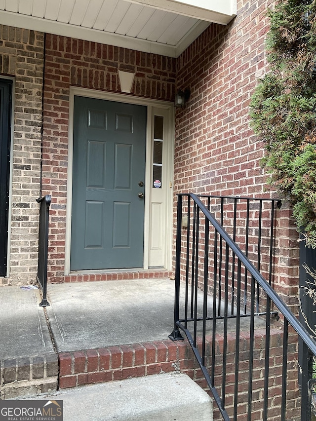 entrance to property featuring brick siding