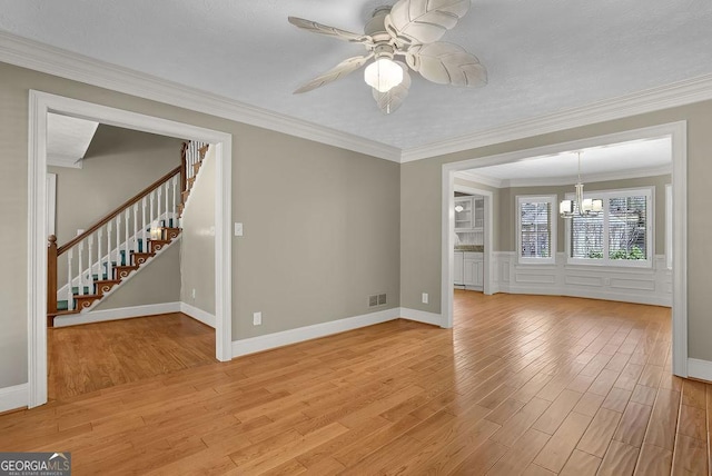 interior space with stairs, crown molding, visible vents, light wood-style floors, and ceiling fan with notable chandelier