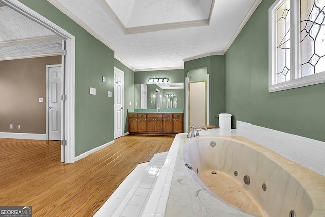 full bathroom featuring baseboards, crown molding, a tub with jets, and wood finished floors