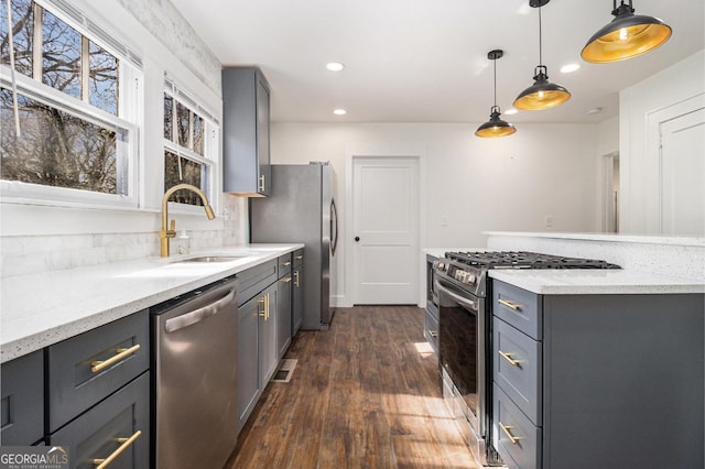 kitchen featuring stainless steel appliances, pendant lighting, a sink, and gray cabinets