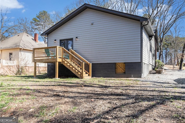 back of property featuring fence, stairway, and a wooden deck