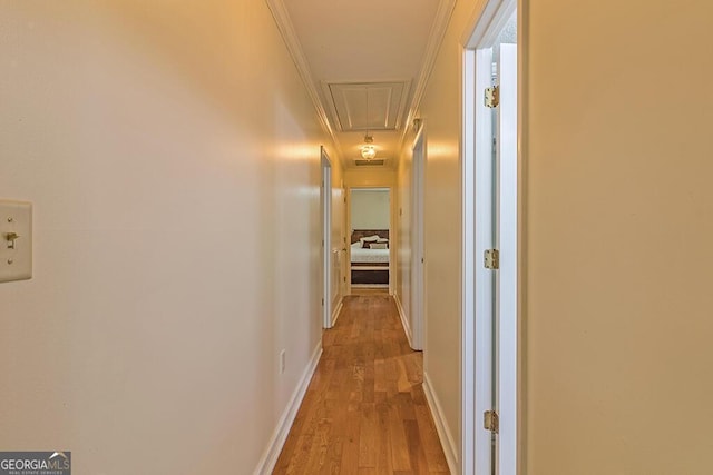 corridor featuring ornamental molding and light wood-type flooring