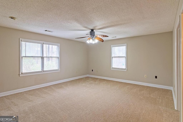 unfurnished room featuring ceiling fan, light carpet, and a textured ceiling