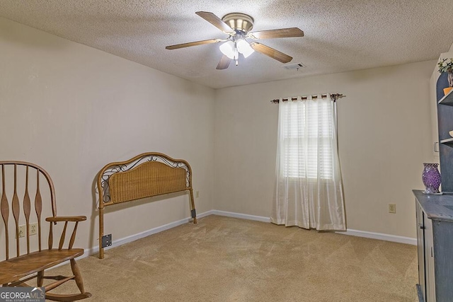 living area featuring light carpet, a textured ceiling, and ceiling fan