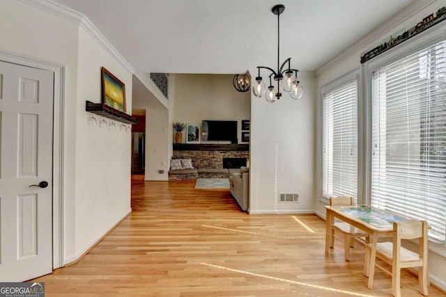 dining room featuring light wood-style flooring, visible vents, a chandelier, and ornamental molding