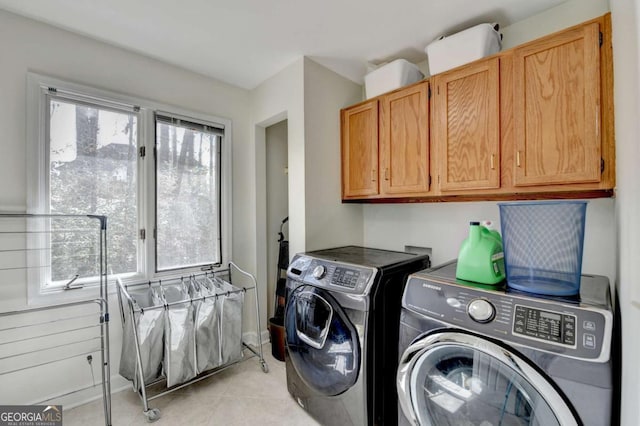 laundry area with light tile patterned flooring, cabinet space, plenty of natural light, and separate washer and dryer