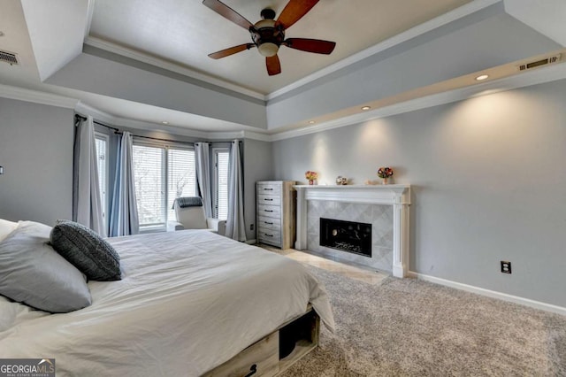 bedroom with light carpet, visible vents, a tray ceiling, and baseboards