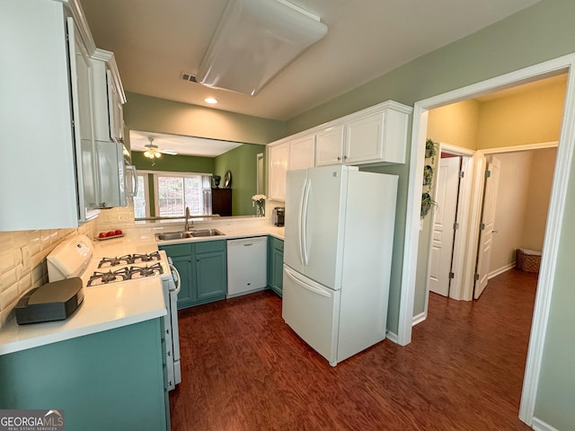 kitchen featuring white appliances, tasteful backsplash, dark wood finished floors, light countertops, and a sink