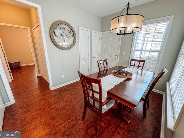 dining area featuring a notable chandelier and baseboards