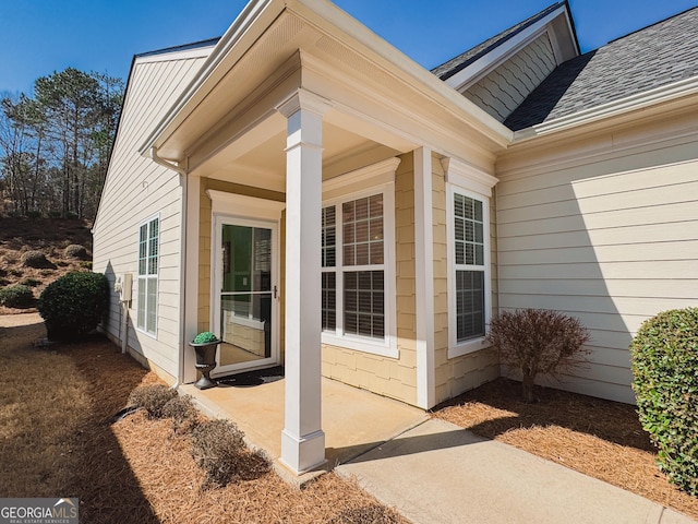 property entrance featuring a shingled roof