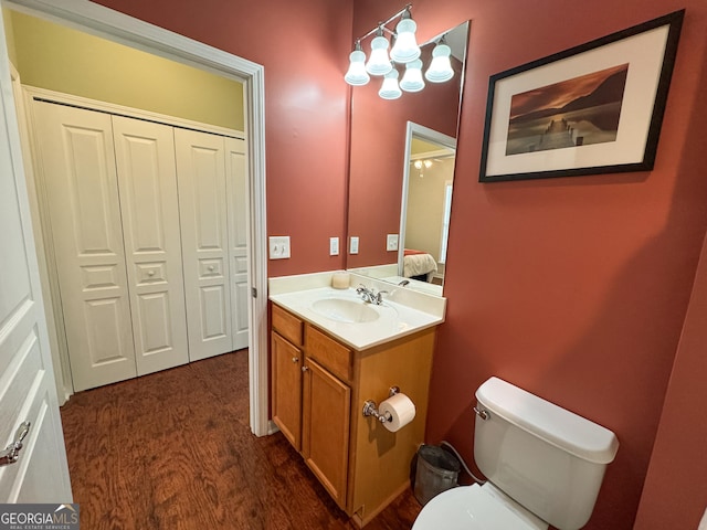 bathroom featuring toilet, wood finished floors, and vanity