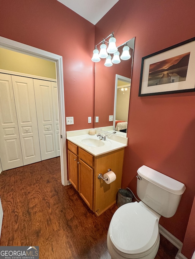 bathroom featuring toilet, wood finished floors, and vanity