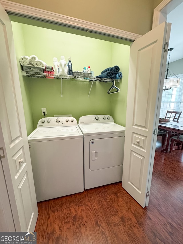 washroom featuring laundry area, washing machine and clothes dryer, and wood finished floors