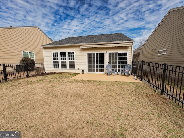 rear view of house featuring a patio, a lawn, and fence