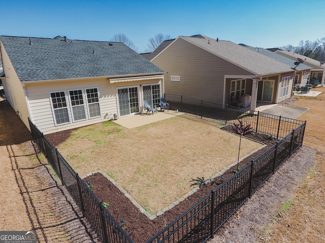 rear view of property with a patio, a yard, roof with shingles, and fence