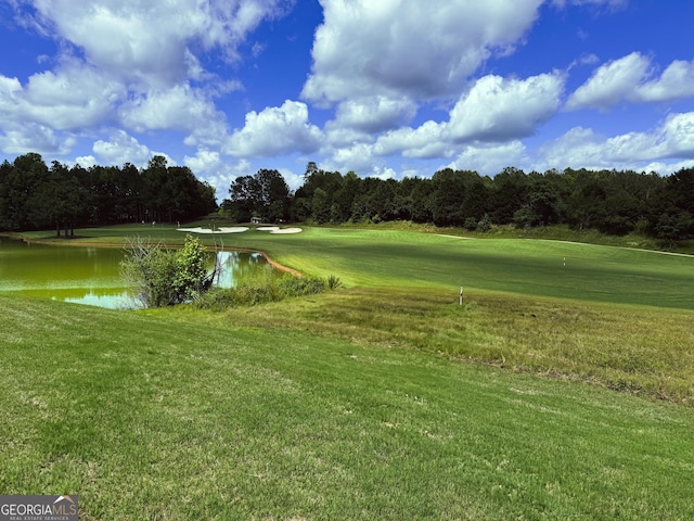 view of community with a lawn, a water view, and golf course view