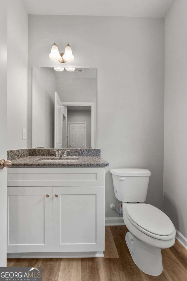 bathroom featuring hardwood / wood-style flooring, vanity, and toilet