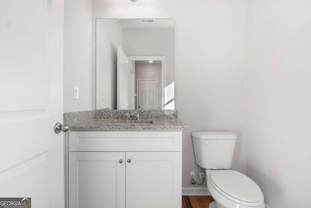 bathroom with vanity, toilet, and wood-type flooring