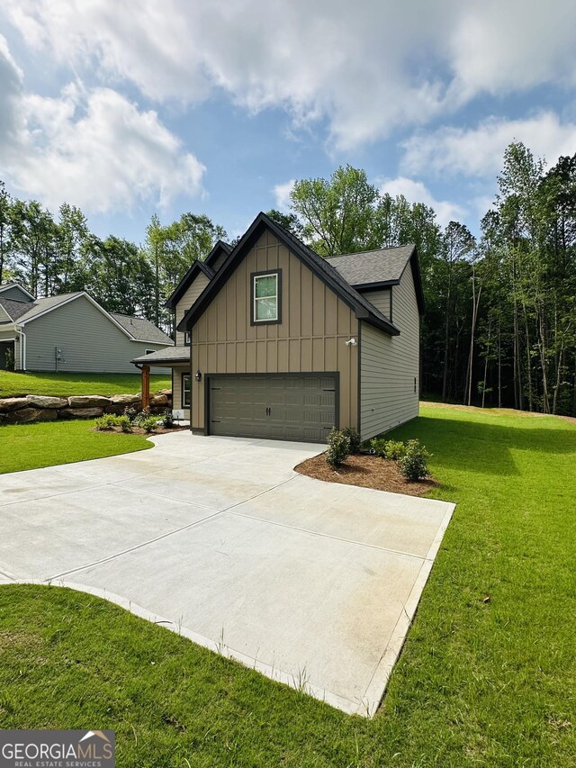 65 Patterson Dr, Franklin, GA 30217 - view of side of property with board and batten siding, a yard, concrete driveway, and a garage
