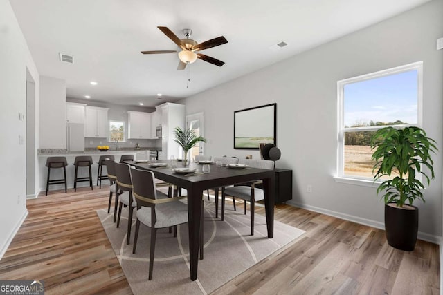 dining room with ceiling fan and light wood-type flooring