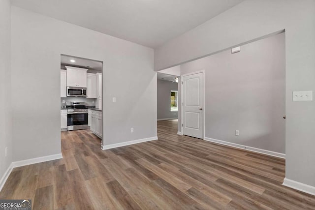 unfurnished living room with dark wood-type flooring