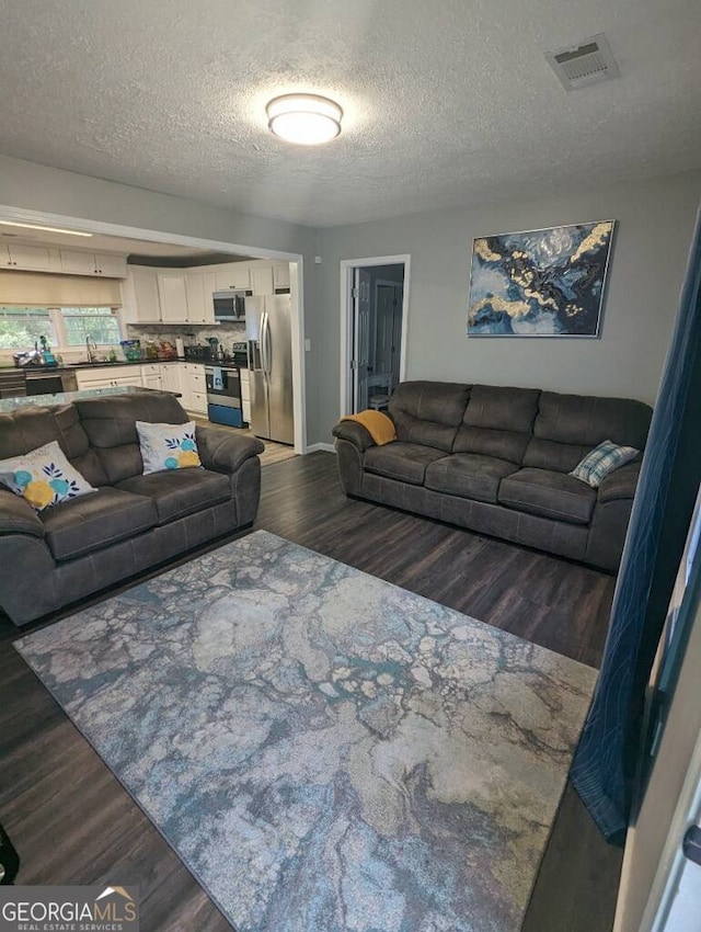 living room featuring dark hardwood / wood-style floors and a textured ceiling