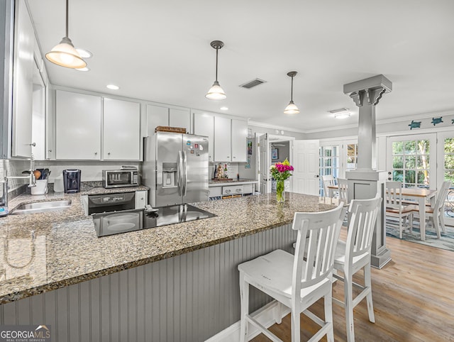 kitchen with white cabinetry, light stone countertops, and black appliances