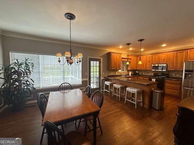 dining area featuring dark hardwood / wood-style flooring, crown molding, and a chandelier