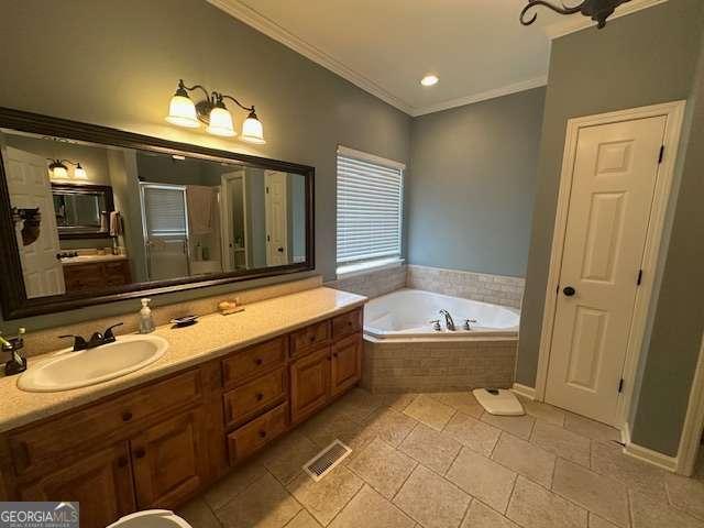 bathroom featuring tiled tub, crown molding, and vanity