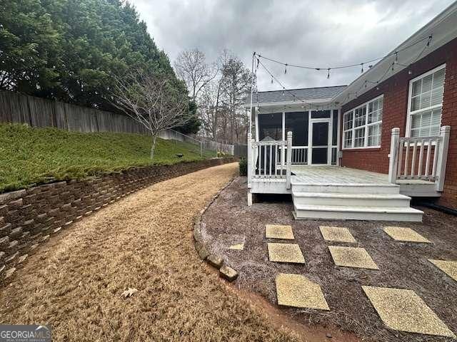 view of yard with a wooden deck and a sunroom