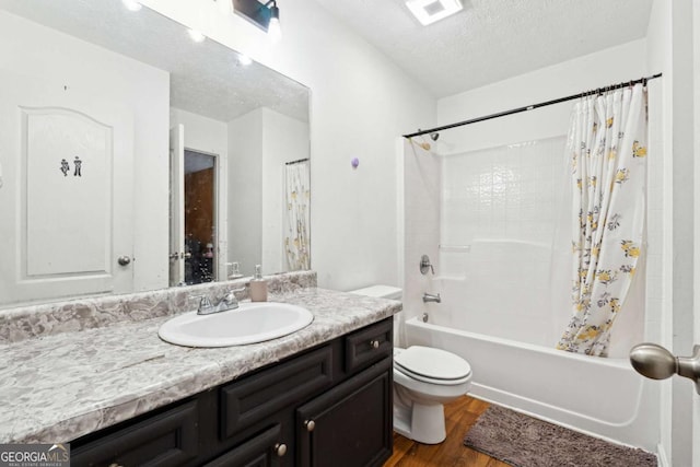 full bathroom featuring toilet, wood-type flooring, shower / tub combo, a textured ceiling, and vanity