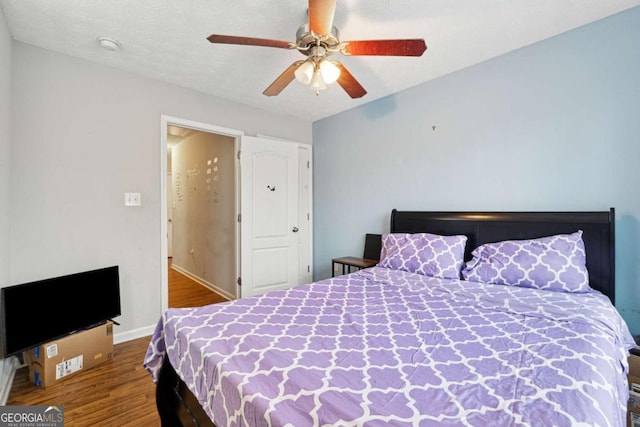 bedroom featuring hardwood / wood-style flooring, a textured ceiling, and ceiling fan