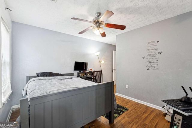 bedroom with ceiling fan, hardwood / wood-style floors, and a textured ceiling