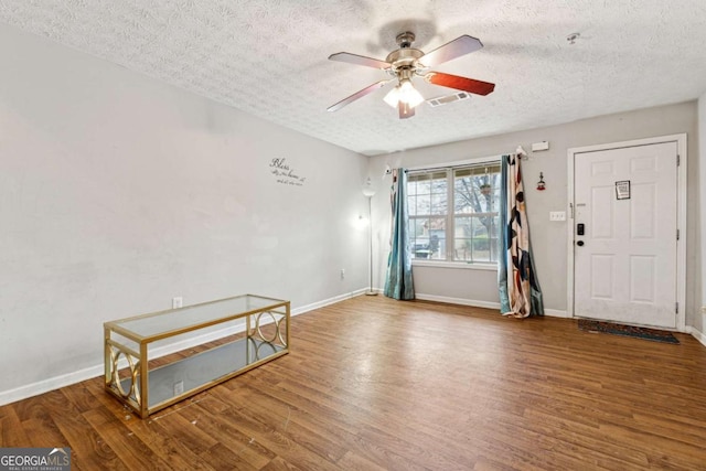 interior space with hardwood / wood-style flooring, a textured ceiling, and ceiling fan