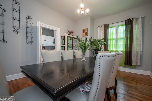 dining space with an inviting chandelier and dark hardwood / wood-style flooring