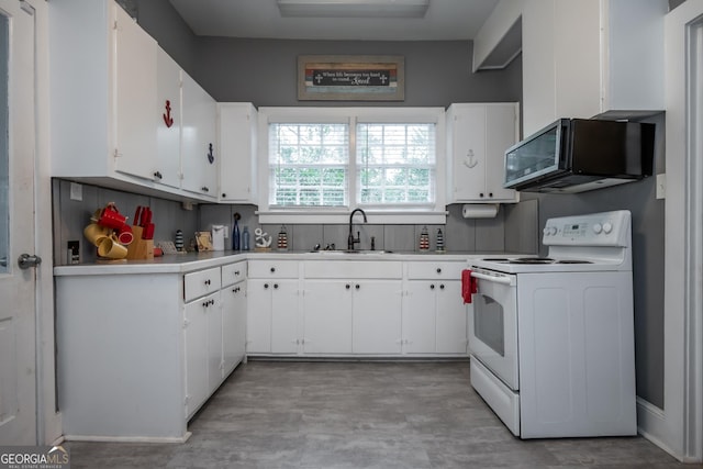 kitchen with tasteful backsplash, white cabinetry, sink, and electric stove