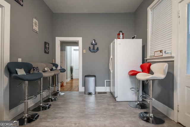 kitchen with white fridge and a breakfast bar area