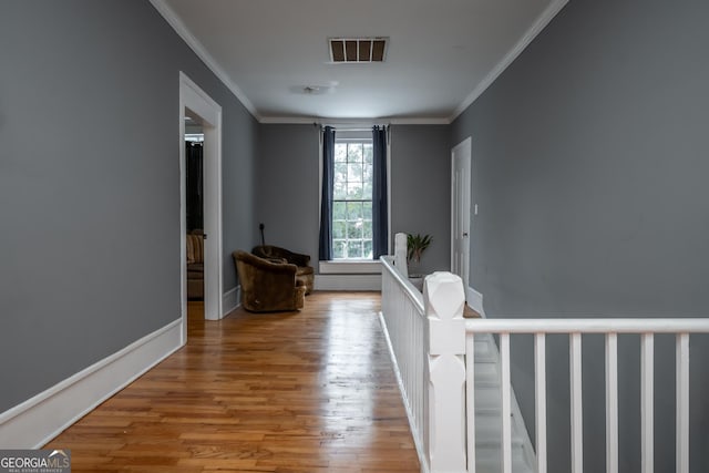 hallway with hardwood / wood-style flooring and ornamental molding