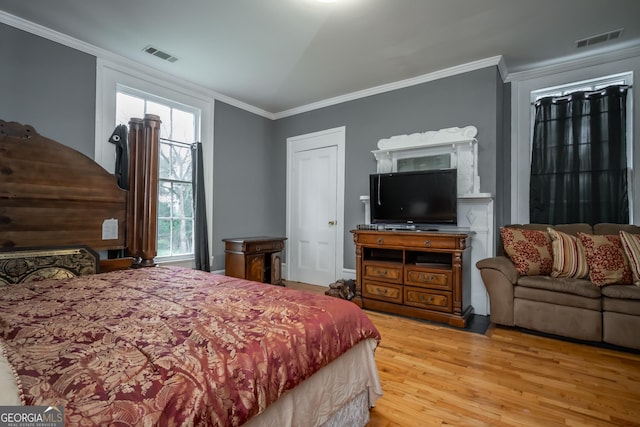 bedroom featuring crown molding and light hardwood / wood-style flooring