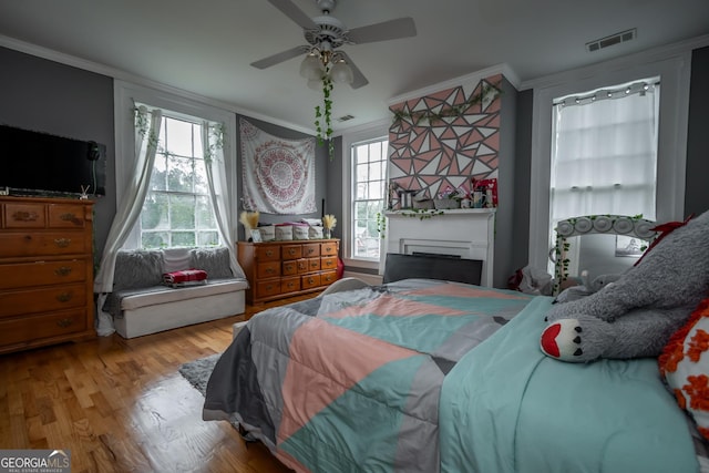 bedroom with ornamental molding, ceiling fan, and light wood-type flooring