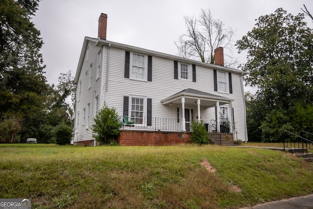 colonial inspired home with a front lawn and a porch