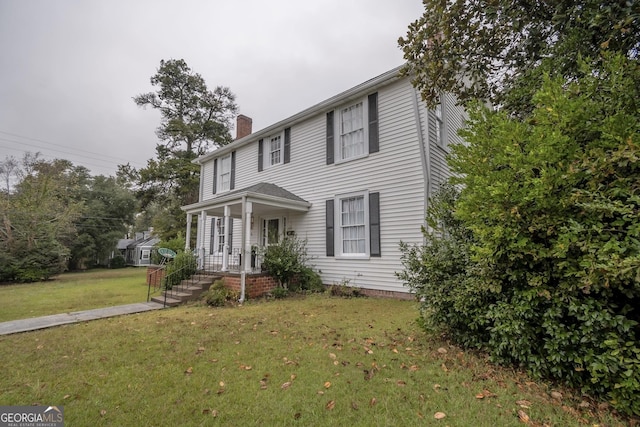 colonial inspired home with a porch and a front lawn